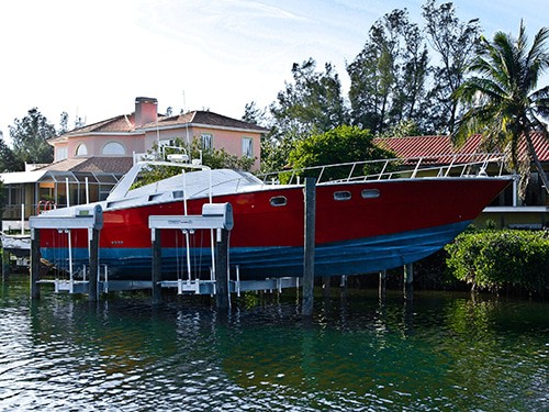 large red boat stored on IMM Quality Superlift boat lift
