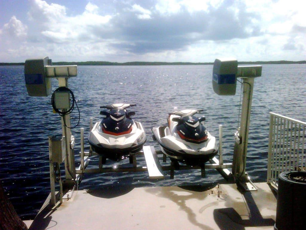 4500 Dual PWC Jet Ski Lift holds two jet skis above the water at the end of a dock
