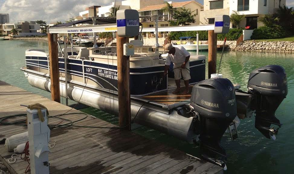 Boat Lift Maintenance in action as IMM Quality Boat Lifts boat owner sprays down deck