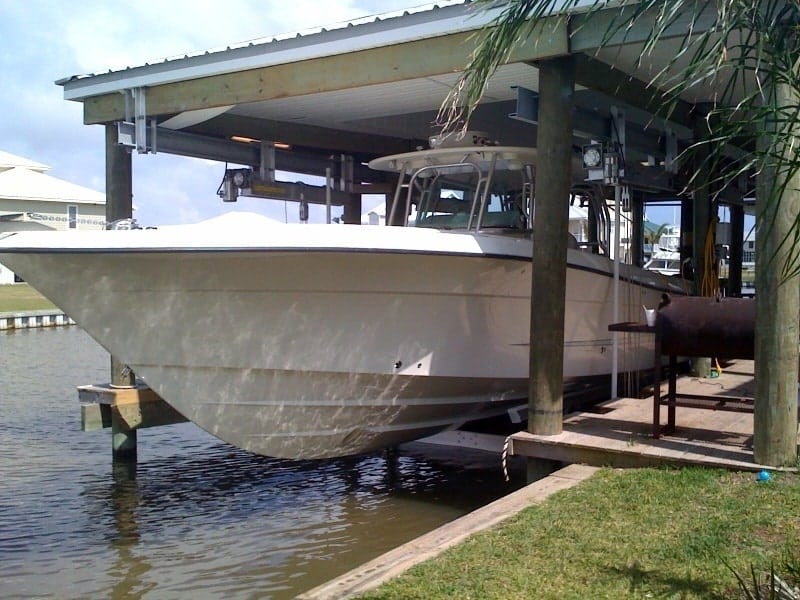 Vintage 2009 IMM Quality Boathouse Lift with large white yacht
