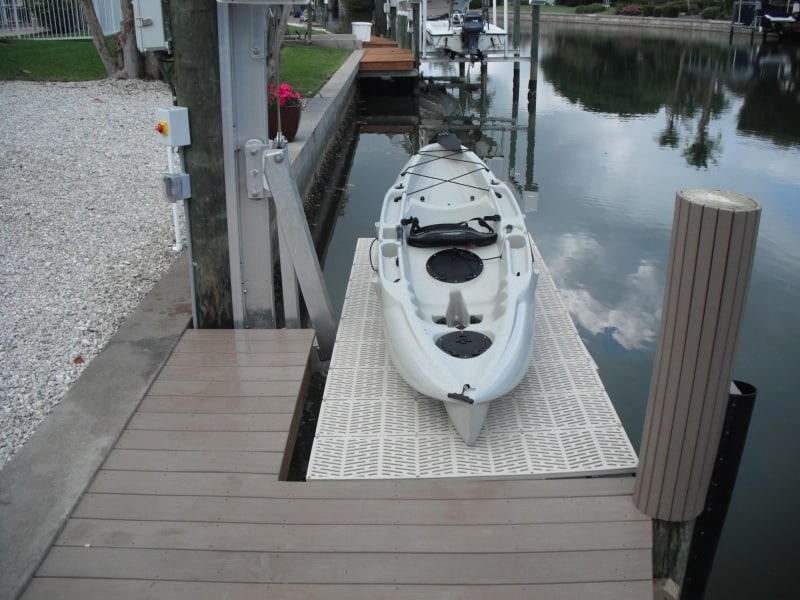 White kayak is lowered using an IMM Quality kayak lift with pile mount