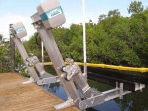 Silver and teal IMM Quality elevator boat lift is an Alumavator model mounted to a brown dock