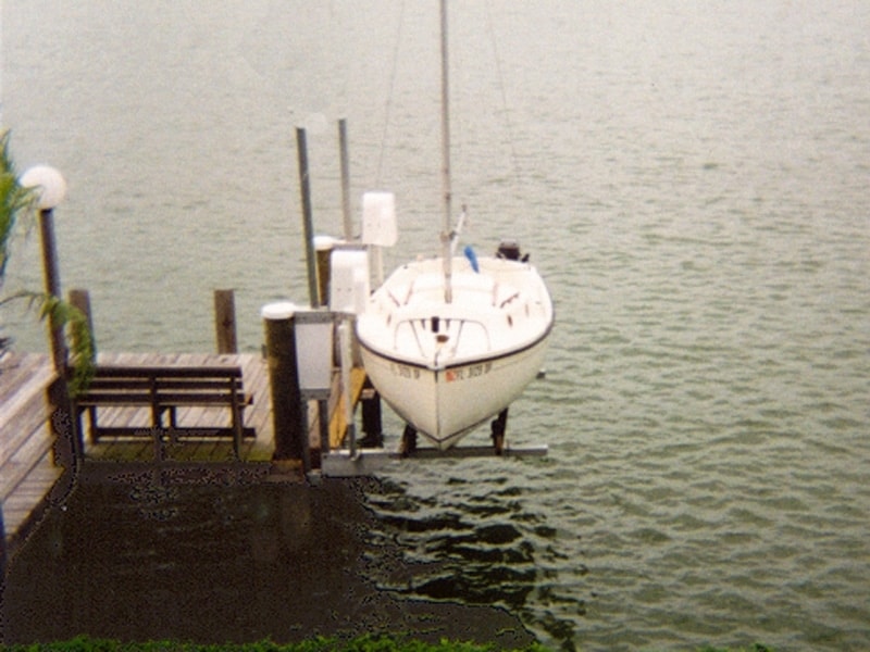 White sailboat is lowered into the water using an IMM Quality boat lift