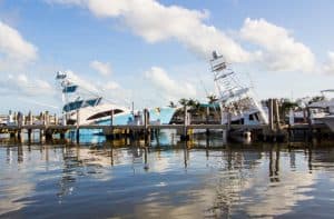 Two leaning boats in marina show the hidden cost of boat ownership after a storm