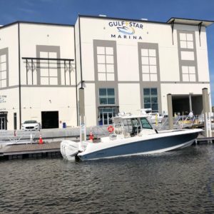 Blue and white boat is raised from the water using an IMM Quality custom superlift at Gulf Star Marina in Fort Myers