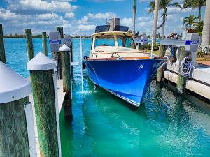Alumavator vertical boat lift allows this large blue high speed boat to easily launch from its boat slip