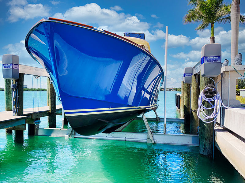 Alumavator vertical boat lifts are ideal for storing high speed boats like the large blue watercraft pictured here