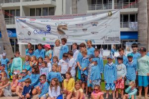 A large group of children in front of the Fishin' with a Mission sign