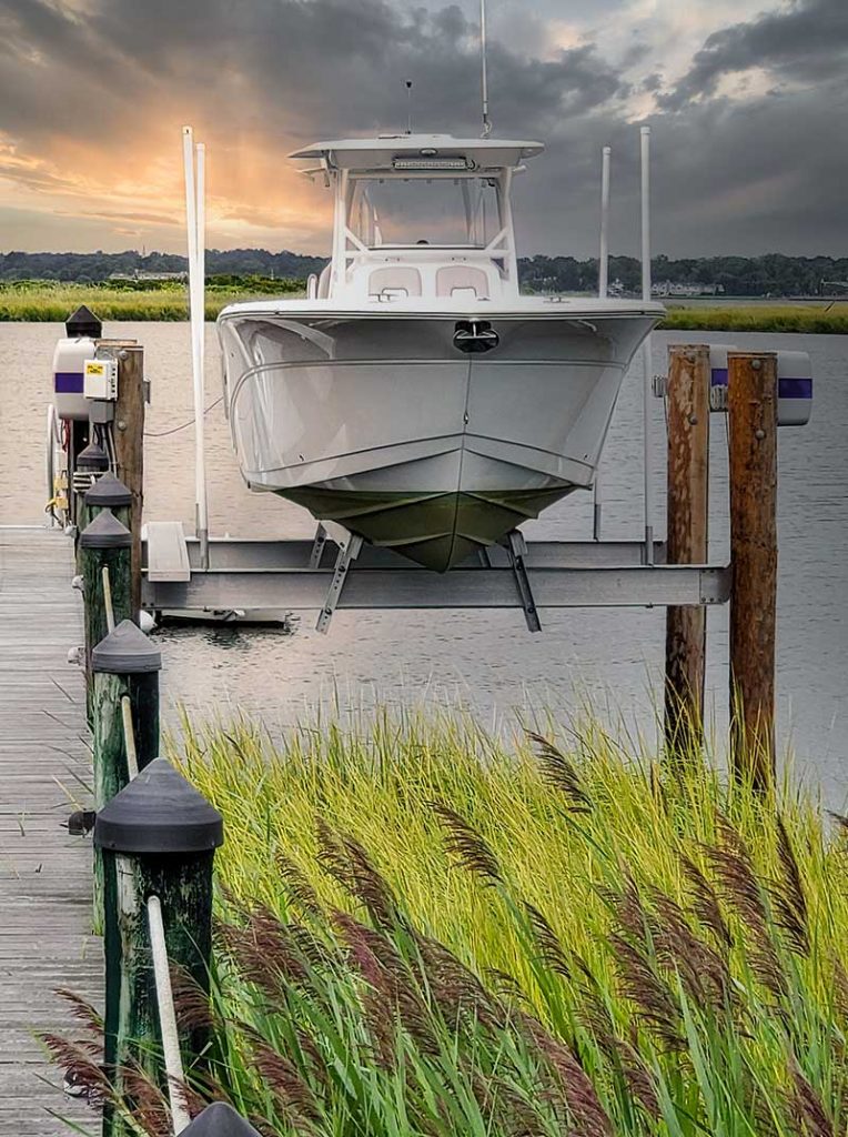 White boat is stored securely on IMM Quality Beamless Boat Lift above seagrass