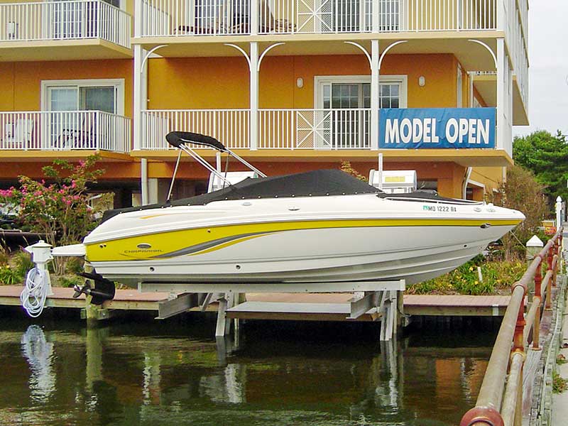 IMM Quality Superlift elevator boat lift with white and yellow boat above the water in Chaparral