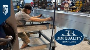 IMM Quality Boat Lifts employee places company sticker on boat lift in advance of National Employee Appreciation Day