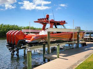 IMM Quality Superlift boat lift with red and black nor tech 450 sport at a dock with shallow water