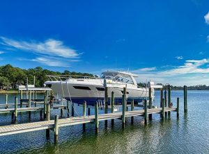 This photo shows what is a boat lift as white boat is raised from the water by an IMM Quality boat lift